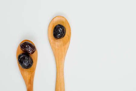 Black and brown olives in a wooden spoons on a white background. close-up.の写真素材