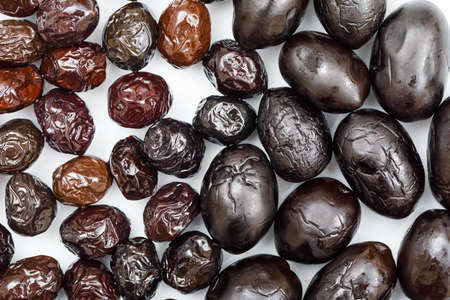 Black and brown olives on a white background. close-up.