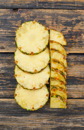 Delightful pineapple slices flat lay on a old wooden grunge background