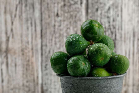 Chilly figs in a mini bucket on a grungy wooden background. close-up.