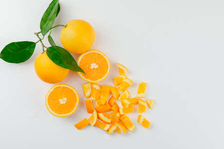 Tasty oranges with branch and slices on white background, top view. の写真素材