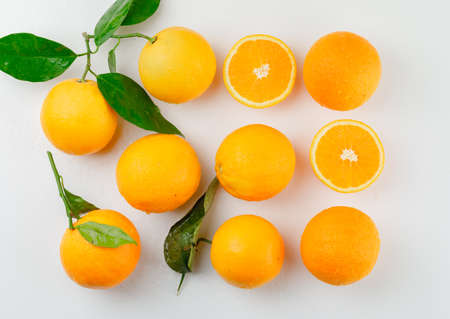 Tasty oranges with branch and slices top view on a white background の写真素材