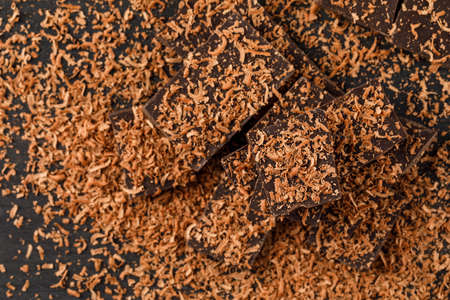 Grated chocolate with choco bars flat lay on a dark background