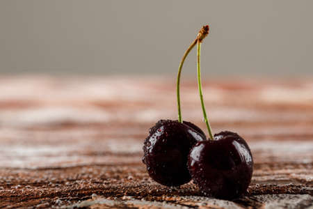 Black cherry berries on wooden and grey background. side view.の写真素材