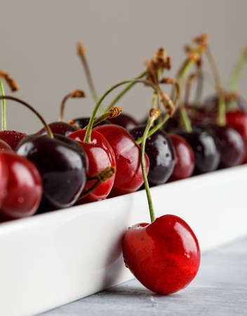 Cherries in a plate close-up on grungy and grey backgroundの写真素材