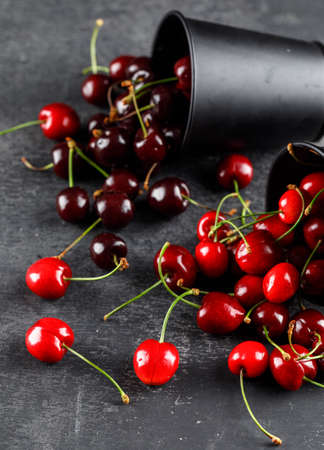 Scattered cherries from buckets on a grungy grey background. high angle view. 