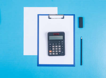 Finance and accounting concept with paper holder, calculator, paper, pencil, eraser on cyan blue background top view. horizontal imageの写真素材