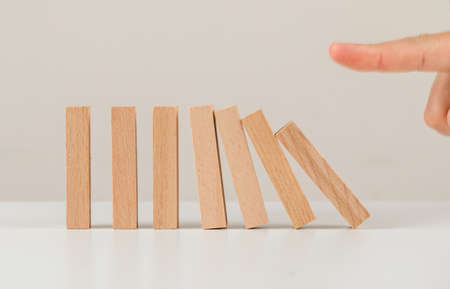 Business planning concept on white backgroud side view. human pushing down wooden blocks.の写真素材