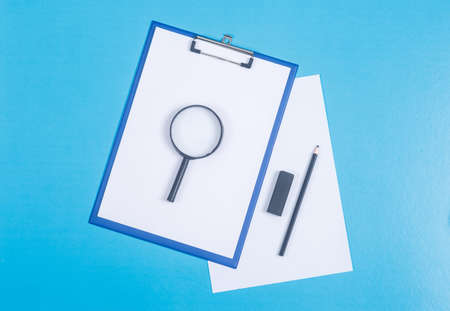 Conceptual of finance and accounting. with paper holder, paper, magnifier, eraser and pencil on cyan blue background top view. horizontal imageの写真素材