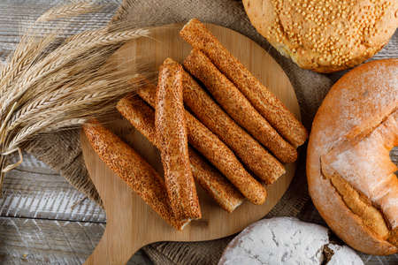 Bakery products with barley top view on a cutting board and woooden background の写真素材
