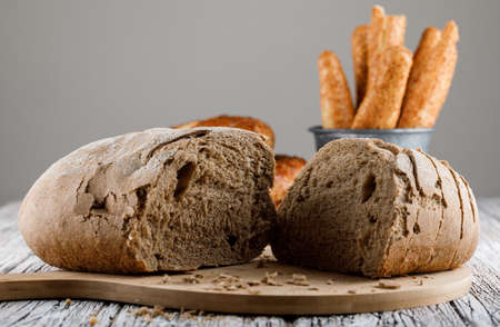 Side view bread divided into half on cutting board with turkish bagel on wooden background. horizontal の写真素材