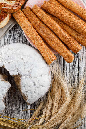 Top view cake divided into half with bagel, barley on wooden background. vertical