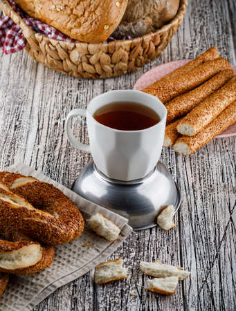 Turkish bagel with a cup of tea on wooden background, high angle view. 