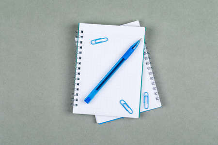 Taking notes and accounting concept with notebook, pen on gray background top view. horizontal image の写真素材