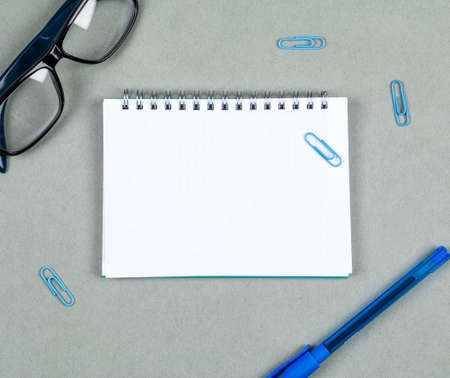 Taking notes concept with notebook, pen, eyeglasses on gray background top view. space for text. horizontal image の写真素材
