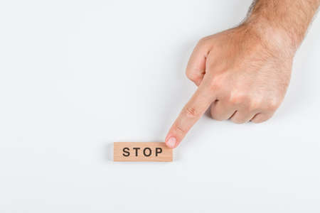 Stop word concept with wooden blocks on white background top view. with hand holding it. horizontal...