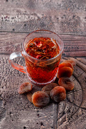 Herbal tea with dried apricots in a cup on stone tile background, high angle view.の写真素材