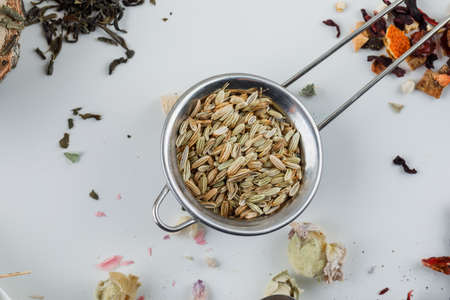 Anise in a small sieve with dried tea flat lay on a white backgroundの写真素材
