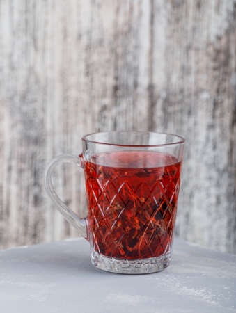 Herbal tea in a cup on plaster and grungy background. side view.