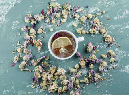 Lemony tea with dried flowers in a cup on plaster background, top view.の写真素材
