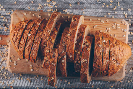 Sliced bread on a cutting board on a wooden background. top view. の写真素材
