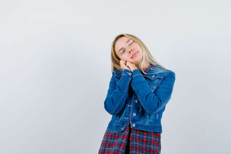 blonde lady leaning on hands as pillow in shirt, jacket and looking relaxed , front view.の写真素材
