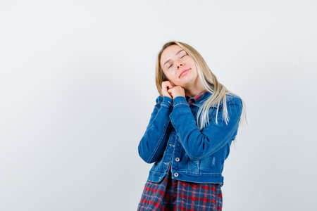 blonde lady in shirt, jacket leaning on clasped hands as pillow and looking peaceful , front view.の写真素材