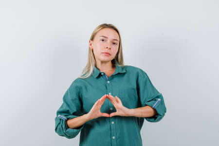 young lady showing crossed fingers in t-shirt, denim jacket, skirt and looking cute , front view.の写真素材