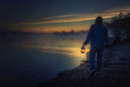 Enjoying the mysterious view at lake on a foggy misty morningの写真素材