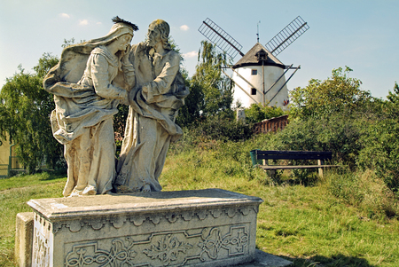 Austria, statue of saints with windmill in backgroundのeditorial素材