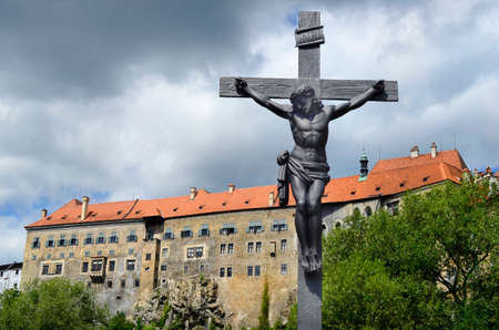 Cesky Krumlov, Czech Republic, thunderclouds and cross with Christ and part of castle Krumlov in the Unesco World Heritage site in Bohemiaのeditorial素材
