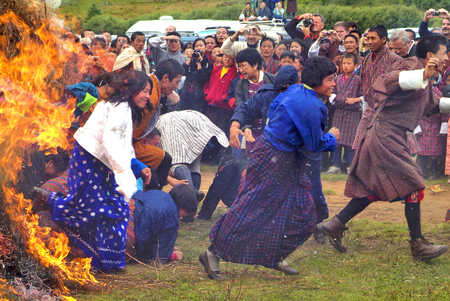 Jakar, Bhutan - September 26th 2007: Unidentified people running through an open fire by the religious fire and smoke ceremony at Thangbi Lakhang to cleans of sinのeditorial素材