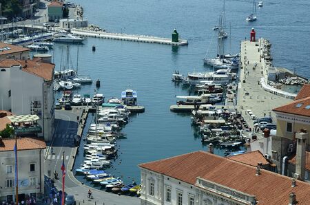Piran, Slovenia - July 4th 2015: Unidentified people around the small harbor in the pictoresque village on Adriatic seaのeditorial素材