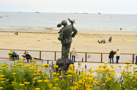 Dinard, France - June 10th 2011: Unidentified people and sculpture of Alfred Hitchcock in remembrance to his movie The Birds, on beach in the city in Brittanyのeditorial素材