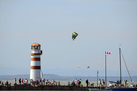 Podersdorf, Austria - April 29th 2012: Unidentified people on jetty with lighthouse and kite surfer on Neusiedler lake in Burgenlandのeditorial素材