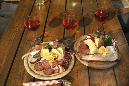 Austria, typical snack named Brettljause with chees, ham,sausage and Schilcher wineの写真素材