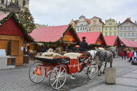 Prague, Czech Republic - December 2nd 2015: Unidentified people on Christmas market on old town square and traditional horse drawn coachのeditorial素材