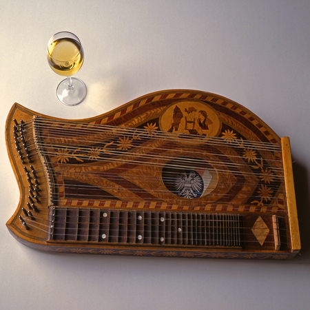 zither with old Austrian emblem and glass of wine - remembrance to movie "The Third Man" and music from Anton Karasのeditorial素材