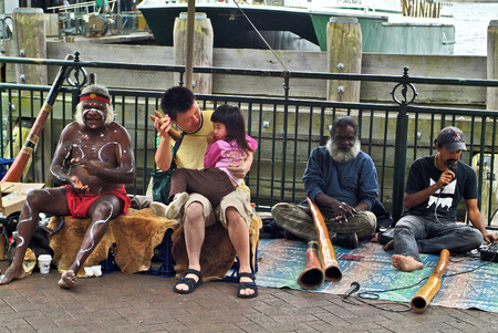 Sydney, Australia - February 8th 2008: Unidentified Aboriginal didgeridoo with traditional and Asian tourists on Circular Quayのeditorial素材