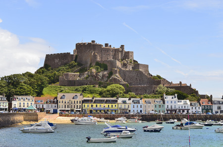 Gorey, United Kingdom - June 9th 2011: Village with harbor and Gorey castle aka Mont Orgueil castle, landmark and tourist attraction on Jersey, one of the channel islandsのeditorial素材