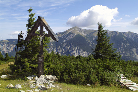 Austria, wayside cross on Rax mountain with Schneeberg mountain behind
