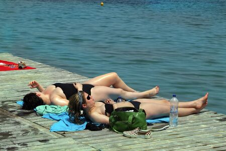 Dasia, Corfu - May 27th 2006: Unidentified woman relaxing on beach of Ionean seaのeditorial素材