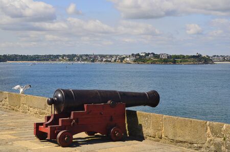 France, medieval cannon on the St. Malo town wall with view to Dinard Villageの写真素材