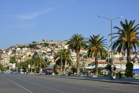 Kavala, Greece - September 17th 2015: Unidentified people and palm trees, buildings and fortress in the city in Eastmacedoniaのeditorial素材