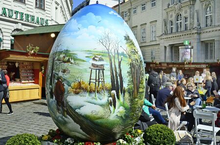 Vienna, Austria - March 27th 2016: Unidentified people, shops and artful decorated giant easter egg on traditional Easter market on Freyung squareのeditorial素材