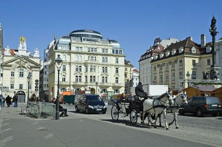 Vienna, Austria - March 27th 2016: Unidentified tourists by sightseeing in traditional horse drawn coach named Fiaker on Am Hof square, a preferred tourist attractionのeditorial素材
