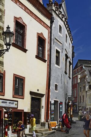Cesky Krumlov, Czech Republic - August 11th 2013: Unidentified tourists in a small street with different shops and house with sgraffito decorated facade in  in Bohemiaのeditorial素材