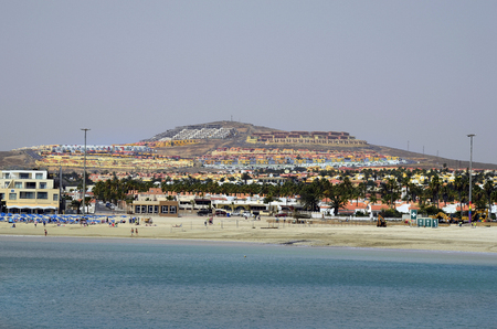 El Castillo, Fuerteventura, Spain - March 31, 2017: Unidentified people on beach in sea ressort with different hotel complexes, preferred travel destination on Canary islandのeditorial素材