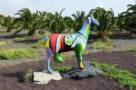 Villaverde, Fuerteventura, Spain - April 01, 2017: Colorful goat sculpture and palm trees in the rural village on Canary Islandのeditorial素材
