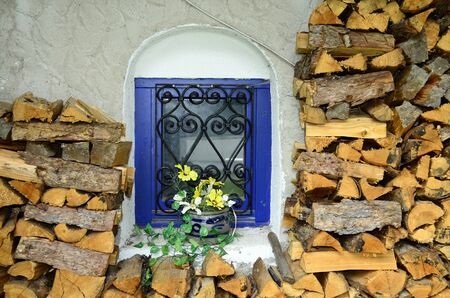 Austria, Tyrol, pile of wood around colorful windowの写真素材